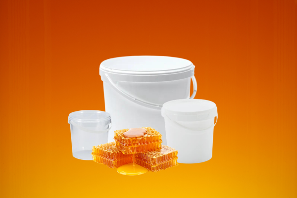 three honey buckets with honey comb on a yellow gradient background